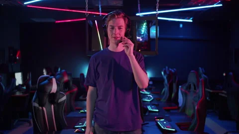 A young guy is preparing for an online games tournament, he puts on headphones Stock Footage 152799369