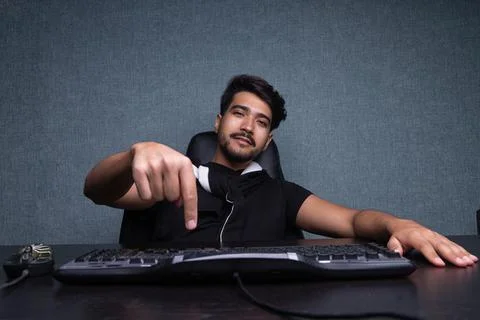 A young guy presses enter on the keyboard. on a gray background. Foto stock