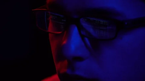 Young guy programmer sitting at computer at night. Displaying monitor on glasses Stock Footage 124360807