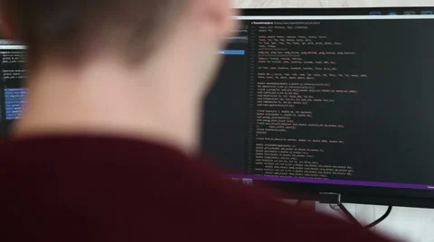 Young guy programmer typing on a keyboard code. back view. Focus on the screen. Video stock 63421298
