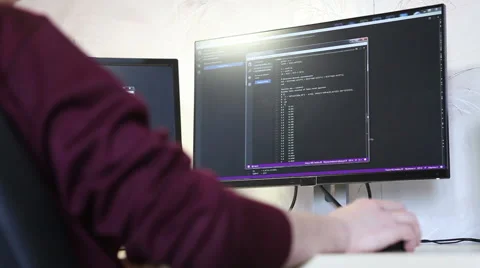 Young guy programmer typing on a keyboard code. back view. Focus on the screen. Video stock 63421305