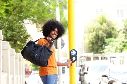 Young guy pushing button to cross street Stock Photos