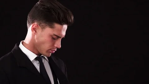 A young guy puts on one earpiece and looks like a serious bodyguard Stock Footage 83587414