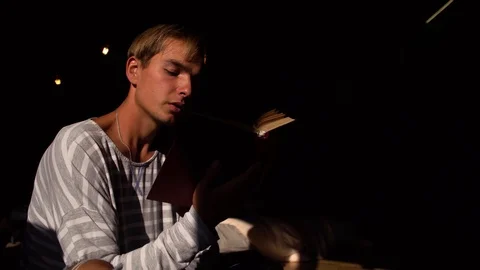 The young guy reads an interesting book, the middle plan Stock Footage 119712075