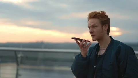 Young guy recording audio message on smartphone 動画素材 162735822