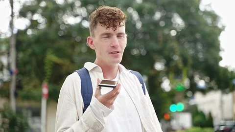 Young guy records a voice message on the street Video stock 167303686