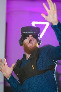 A young guy, with a red beard, is playing virtual reality games Stock Photos