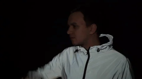 Young guy in a reflective jacket hiding from the paparazzi Stock Footage 150787257