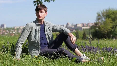 A young guy is resting on the grass. Stock Footage 75549307