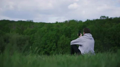 Young guy resting making selfie on nature in the mountains on a sunny day Stock Footage 131085411