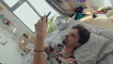 Young Guy Resting in Trendy Designed Room and Texting on Phone Stock Footage 235657531