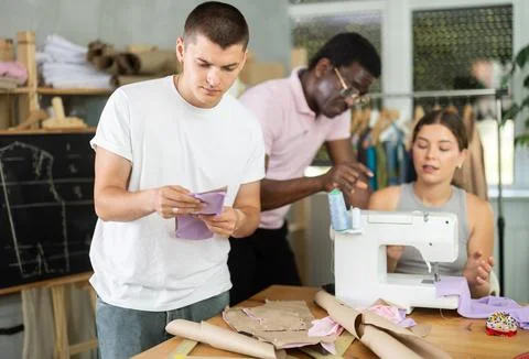 Young guy reviewing paper pattern in training sewing workshop Stock Photos