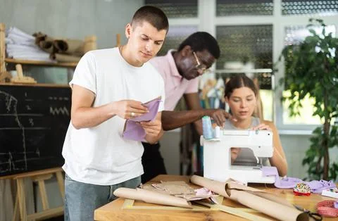 Young guy reviewing paper pattern in training sewing workshop Stock Photos