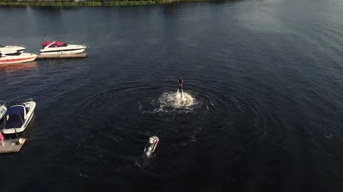 Young guy is riding a flyboard near the pier. training. sunset. Drone view. Stock Footage 160756316