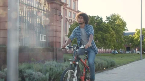 Young guy riding his bicycle on a sunny day Видео 144992197