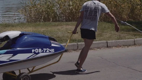Young guy rolls on a trailer hydrocycle Stock Footage 90631834