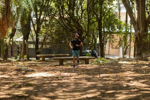 Young guy running and jogging at a park outdoors. Athlete male person during  Stock Photos