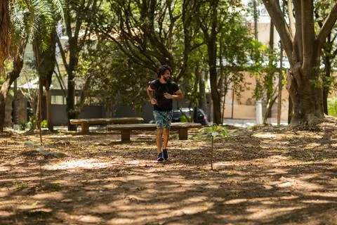 Young guy running and jogging at a park outdoors. Athlete male person during  Stock Photos