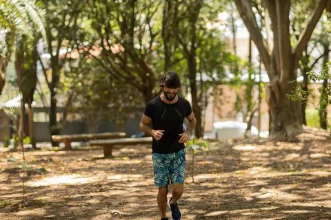 Young guy running and jogging at a park outdoors. Athlete male person during  Stock Photos