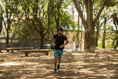 Young guy running and jogging at a park outdoors. Athlete male person during  Stock Photos