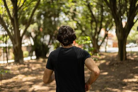 Young guy running and jogging at a park outdoors. Athlete male person during  Stock Photos