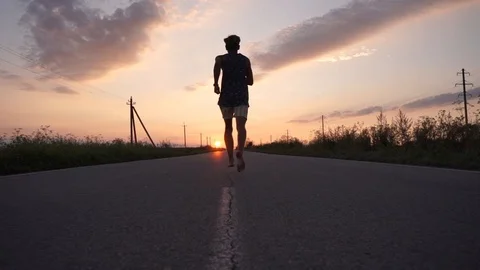 Young guy running on asphalt at sunset Stock Footage 114631448