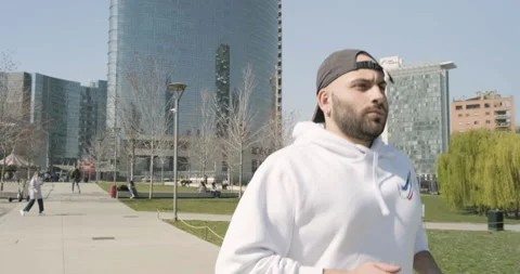 Young guy runs behind vertical forest in Milan, Italy Stock Footage 172527541