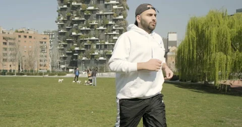 Young guy runs behind vertical forest in Milan, Italy Stock Footage 172527770