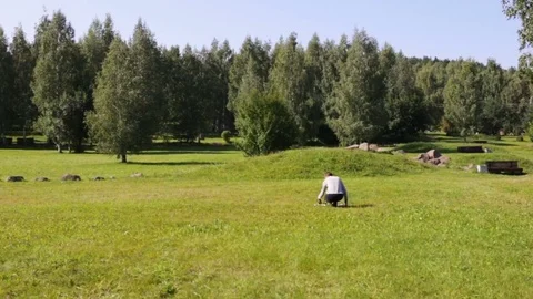A young guy runs up to the drone. The drone lying on the grass, it fell out. The Stock Footage 84913424