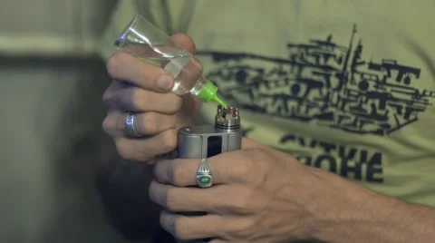 Young guy runs the e-cigarette while holding it in your hand Stock Footage 69067494