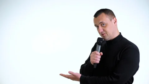 Young guy says something in a microphone on a white background. Stock Footage 129225688
