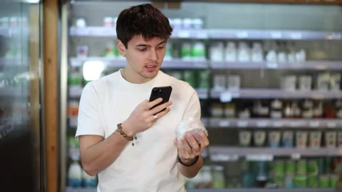 Young guy scanning qr code for cheese Stock Footage 308604346