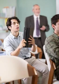 Young guy scanning QR-code with mobile devices during presentation Foto stock