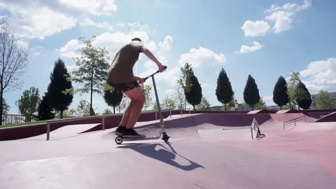 Young guy on scooter perform tricks in skate park 스톡 동영상 102249272