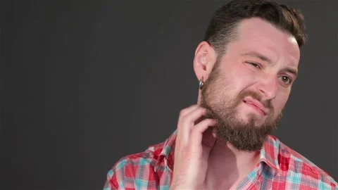 Young guy scratches his beard Stock Footage 251463399