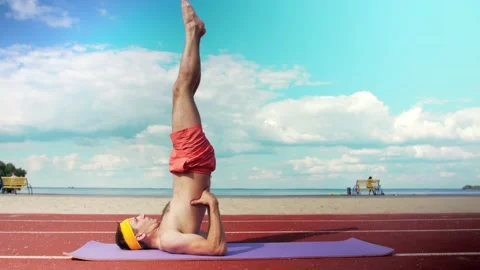 Young guy in shorts without a T-shirt is doing fitness on the playground. Stock Footage 199252660