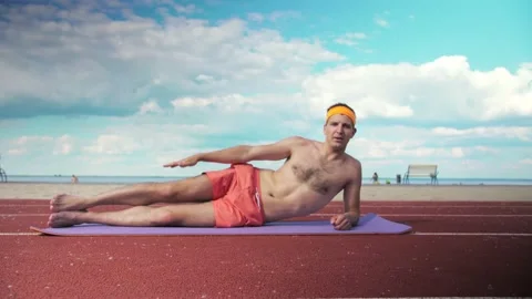 Young guy in shorts without a T-shirt does the exercise of lifting his legs  Stock Footage 199252877