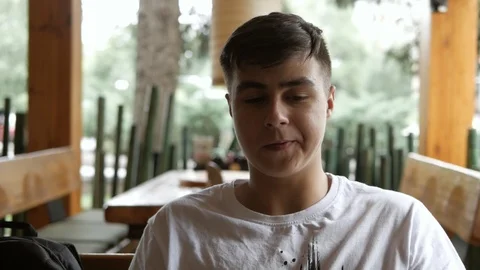 A young guy sitting in a bar drinks a cocktail through a straw. Video stock 113628316