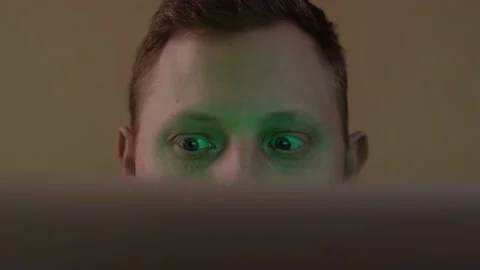 Young guy is sitting behind the screen and can't take his eyes off Stock Footage 169468593