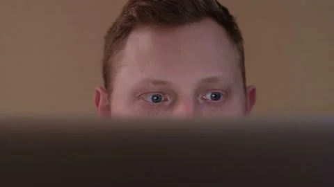 A young guy is sitting behind the screen and looking for information on the Stock Footage 169468635