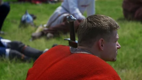 Young guy is sitting on the grass Stock Footage 82408395