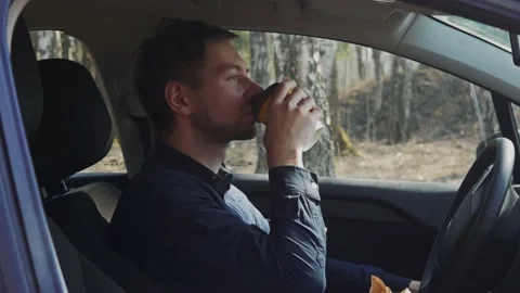 Young guy sitting in his car drinking his morning coffee to cheer himself up Stock Footage 158185106