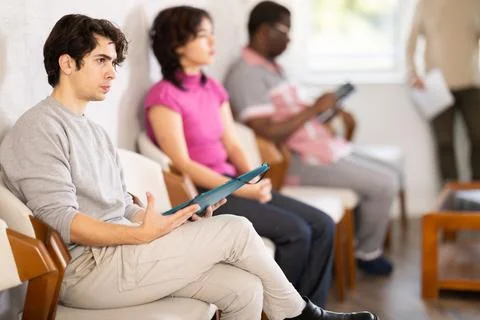 Young guy sitting in a queue at a modern office Stock Photos