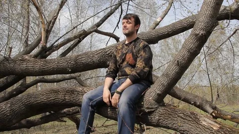 A young guy sitting in a tree Stock Footage 75336114