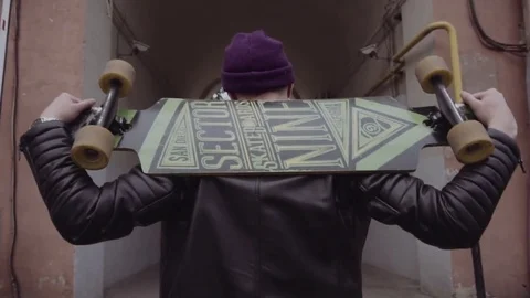 Young guy with a skateboard walking down the street. Scateboard boy Stock Footage 83031528