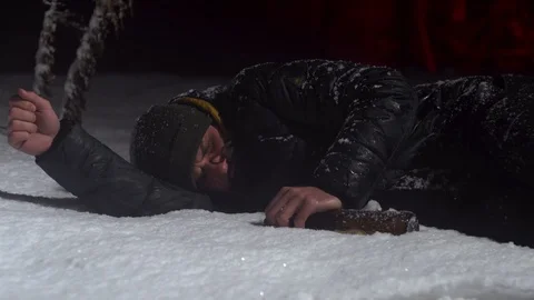 Young guy sleeping in a pile of snow with a bottle in his hands. Young alcoholic Stock Footage 122296005