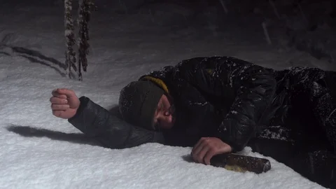 Young guy sleeping in a pile of snow with a bottle in his hands Stock Footage 122296020
