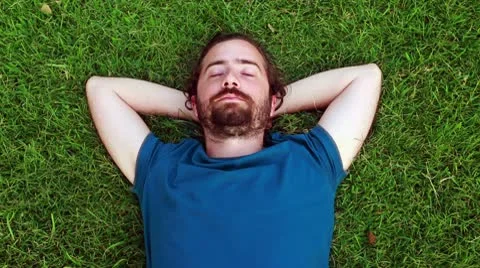 Young guy sleeps on grass Stock Footage 10588207