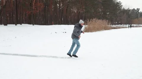 A young guy sliding the slippery street. Funny man feel himself Stock Footage 328731264