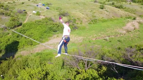 A young guy on a sling goes on a strop at a high altitude Stock Footage 131851947